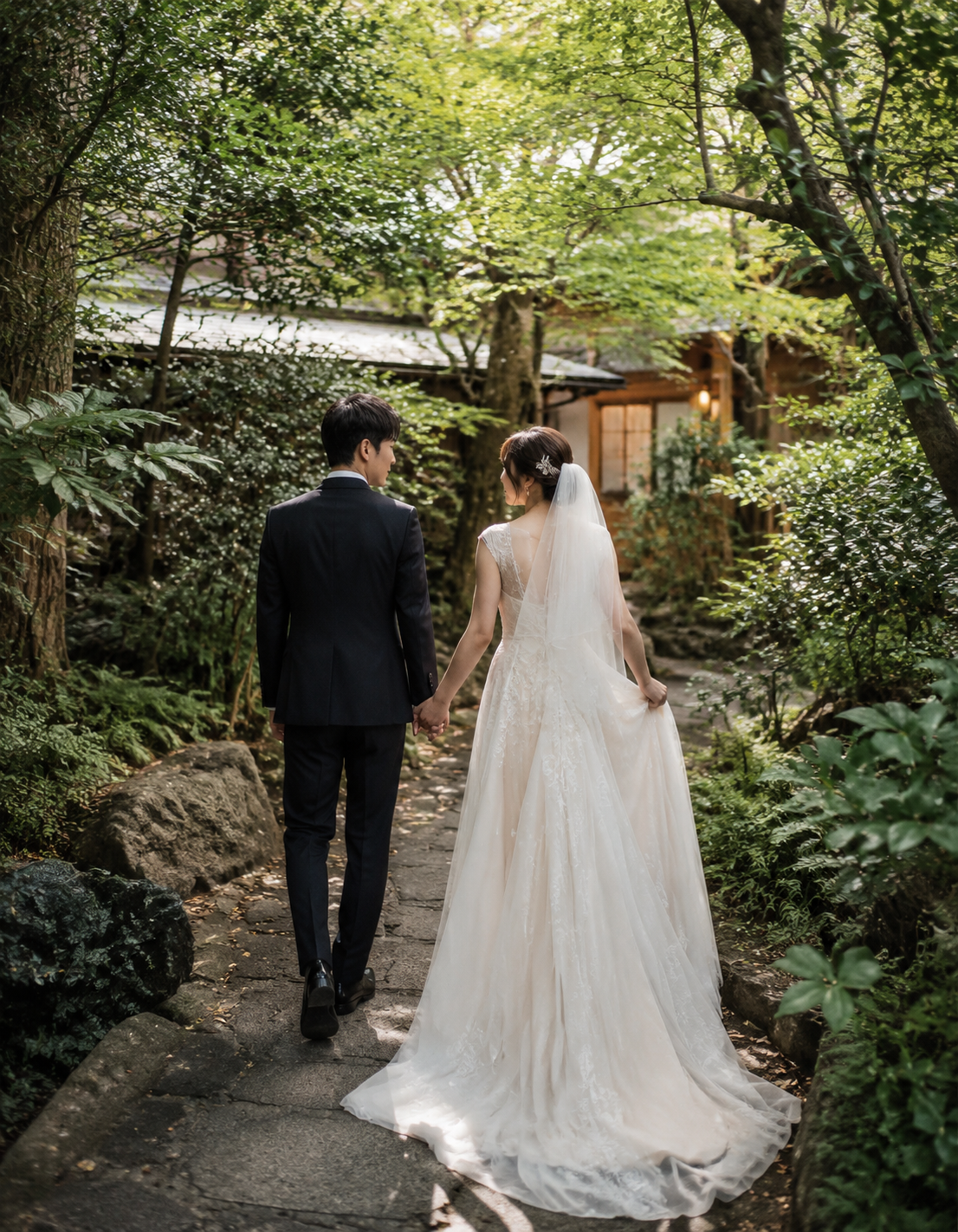 庭園の緑に囲まれて歩く新郎新婦の後ろ姿